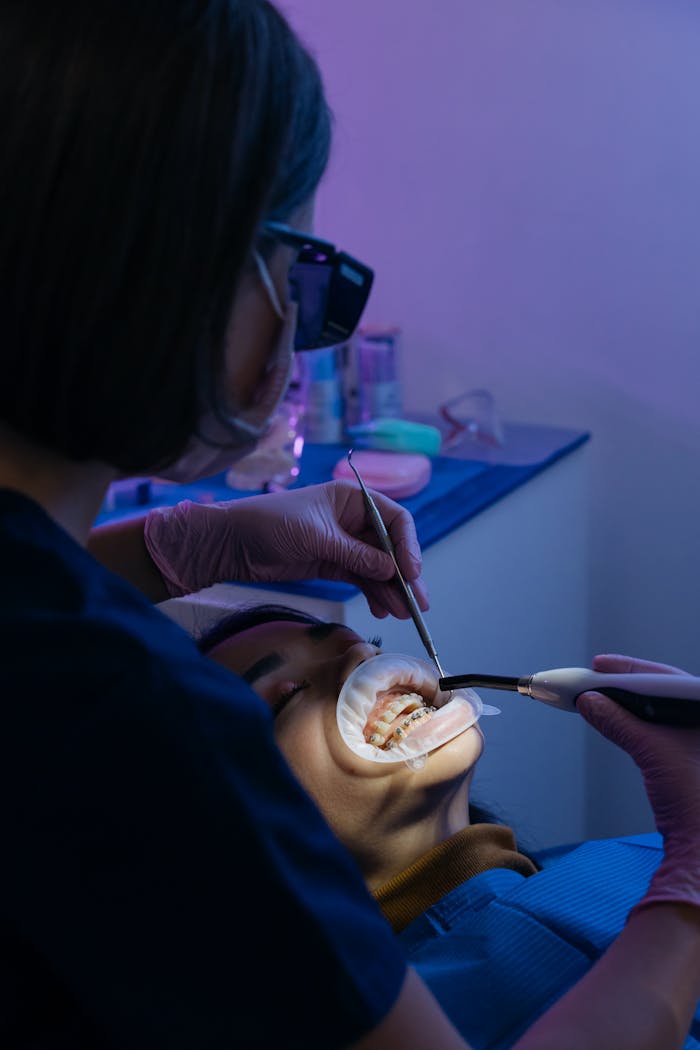 A dentist performing a dental procedure on a patient in a modern clinic setting.